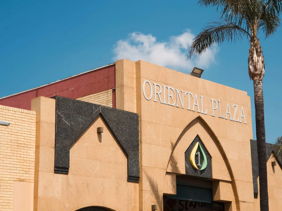 Entrance 1: a sandstone arch with the Oriental Plaza lettering, the logo and palm trees