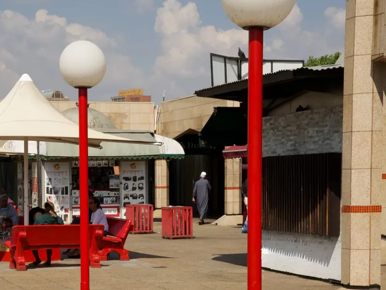 Red lamp posts and red benches in an open-air courtyard