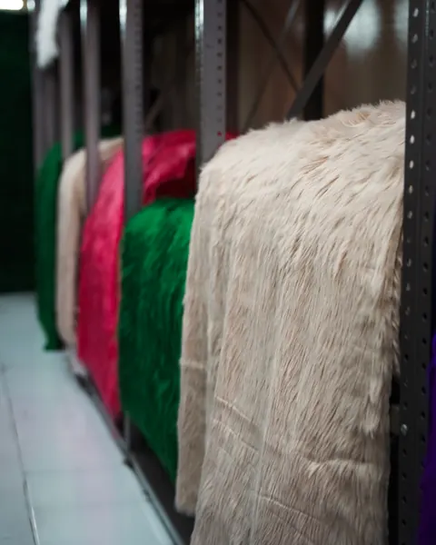 Bolts of red, green and cream fabric on a shop rack
